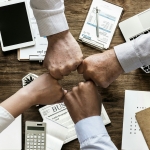 Personal Loan - united hands above an office desk